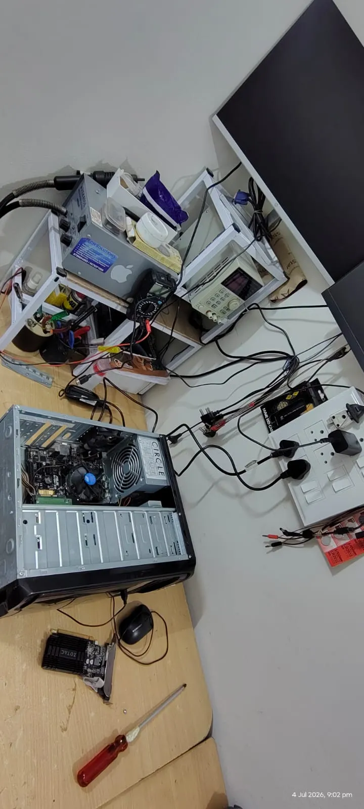 Desktop PC internals with graphics card and tools during reassembly